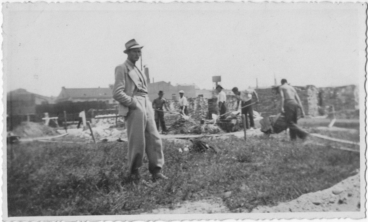 Old photograph showing Jan Tomasik supervising work on a building site in prewar Poland